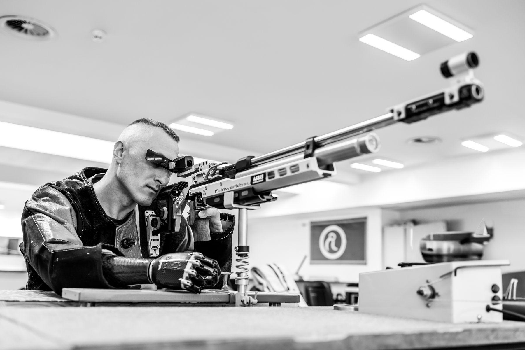 Air rifle shooter in competition, aiming down the range